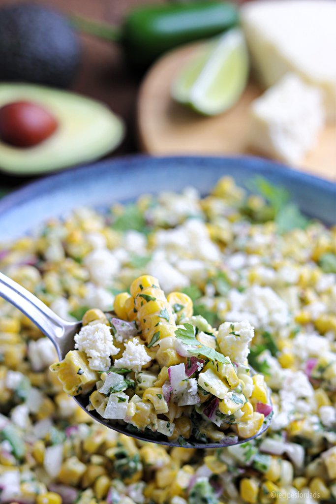 Cuillère pleine de salade de maïs grillé mexicaine